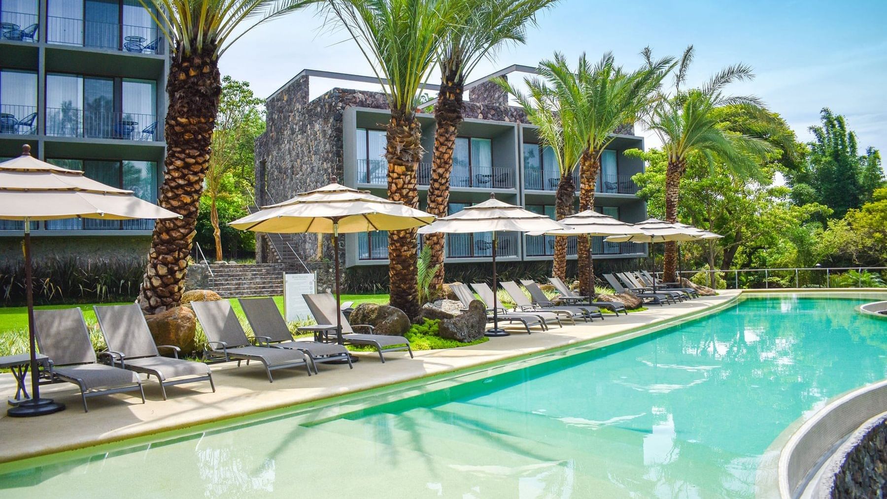 Pool area with lounge chairs at Huayacan Cuernavaca Curamoria