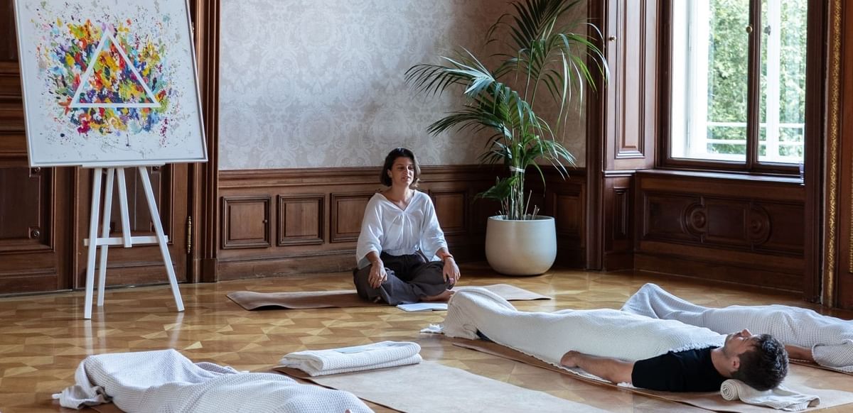 People relaxing on the white mats in Arts with Eyes Shut at Almanac Palais Vienna