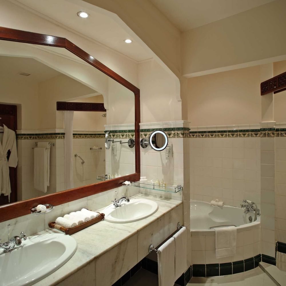 Elegant bathroom with dual sinks and a large bathtub at Zanzibar Serena Hotel in Zanzibar.