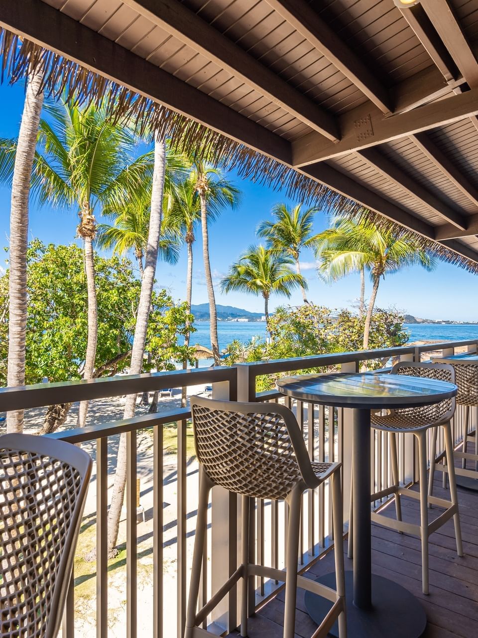 Mesas altas y taburetes en la terraza de Palomino Bar & Restaurant en Las Casitas Village.