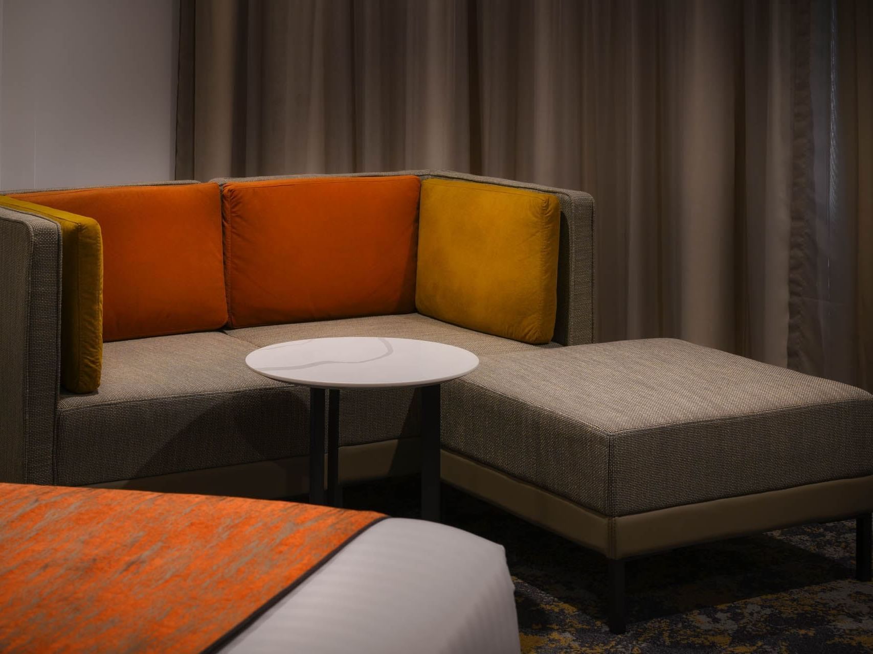 Lounge area with comfy sofas & a stool in a room at Grand Chancellor Hobart