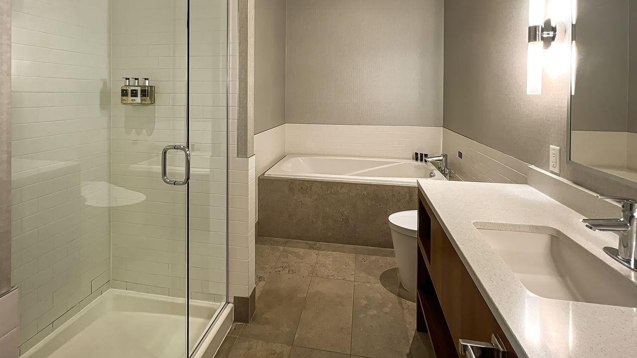 Modern bathroom with large mirror, sink, bathtub, shower room, and toilet
