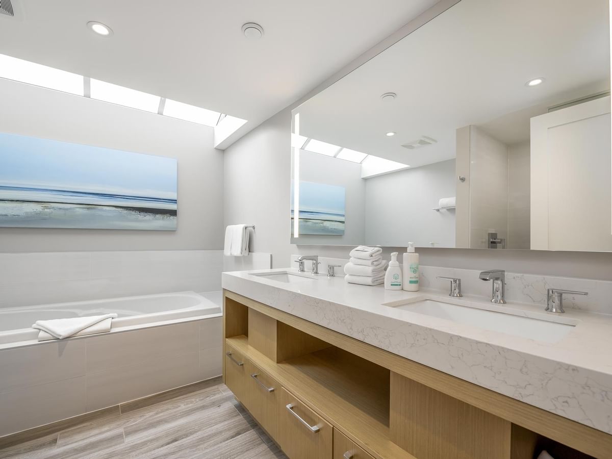 View of the bathtub and large vanity with two sinks