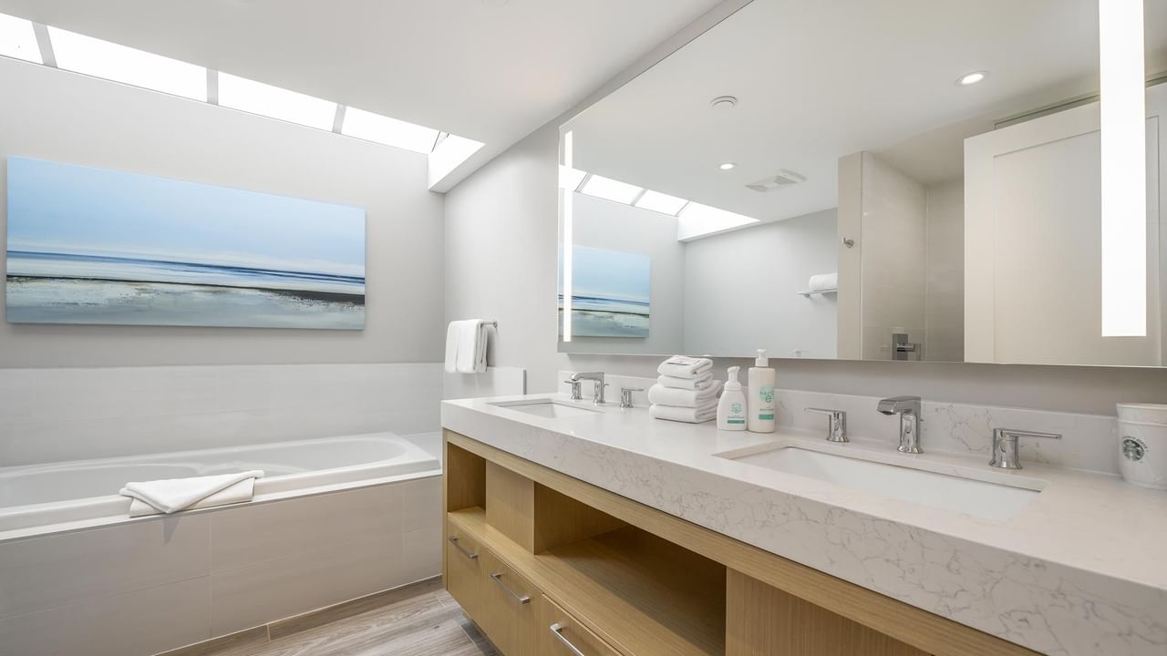 View of the bathtub and large vanity with two sinks