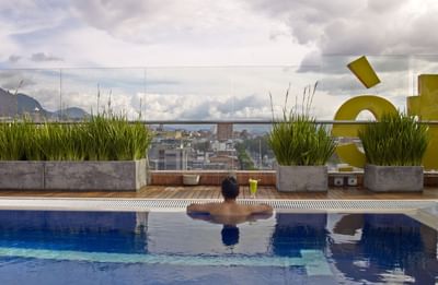 man in pool looking at city