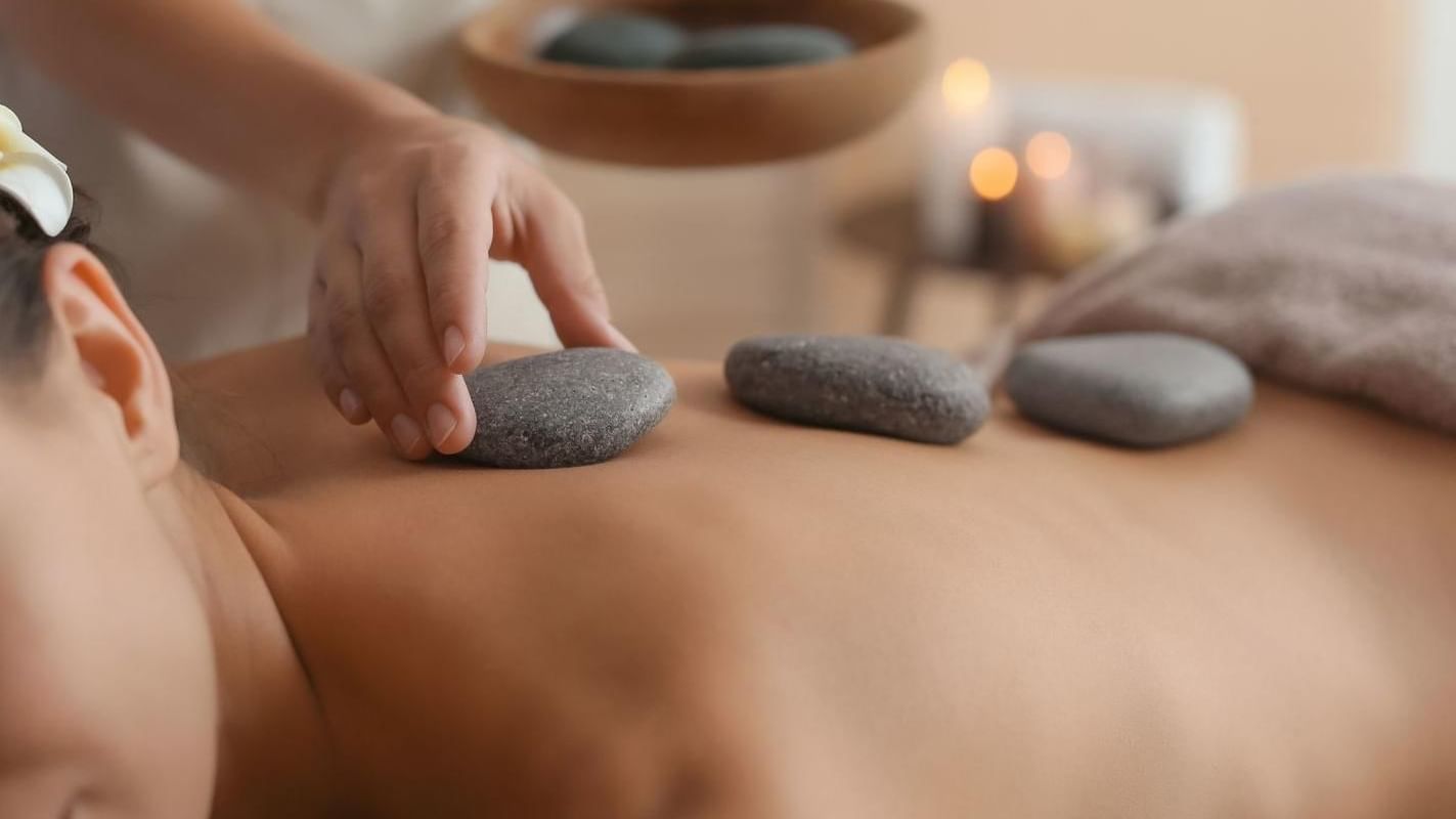 A woman having a hot stone massage at Live Aqua Private Residences Los Cabos