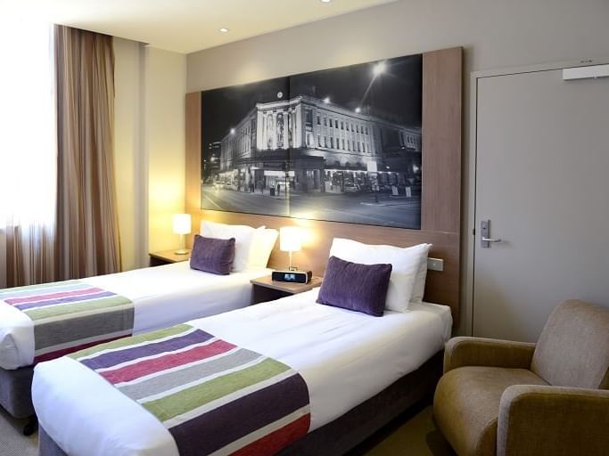 Superior room with 2 Single Beds and a chair at Grosvenor Hotel