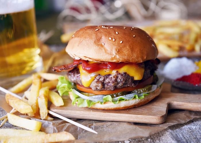 Close-up of a served hamburger with fries at Ogunquit Collection