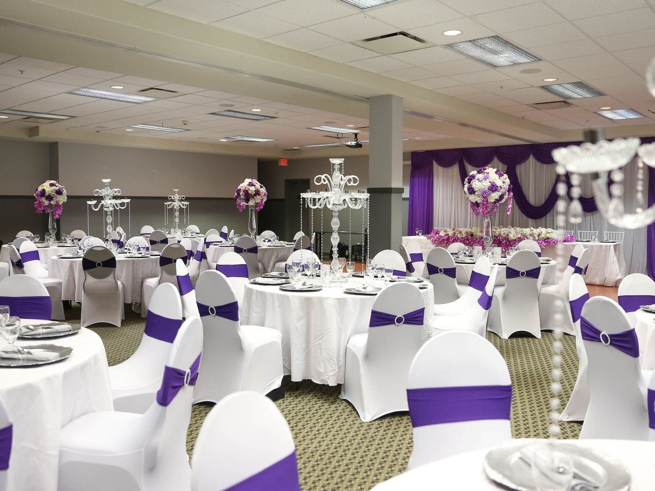 Banquet set-up with flower decor in Emerald B at Merit Hotel & Suites