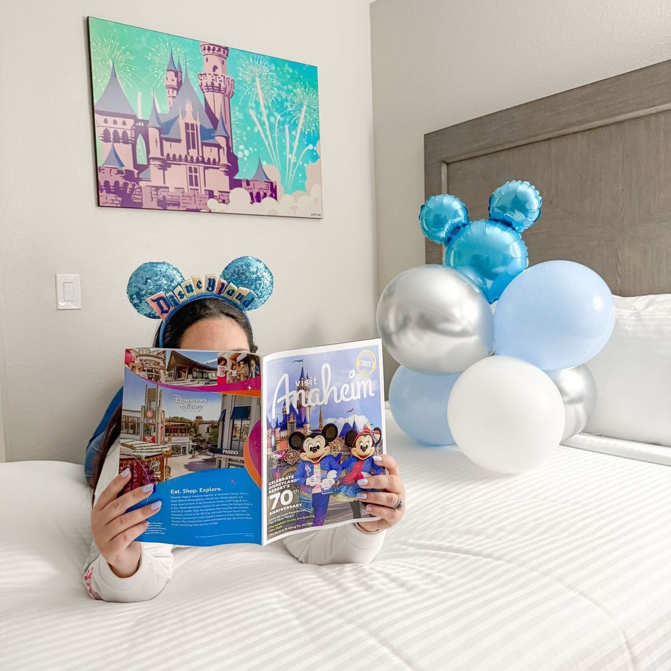 Women in bed reading an Anaheim magazine
