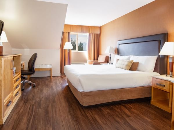 Hotel room with king bed, TV, work desk and window