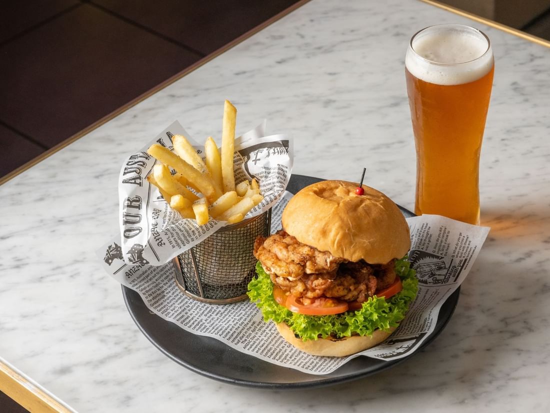 Burger and fries served with beer glass in BAR THIRTY6 at Pullman Sydney Hyde Park