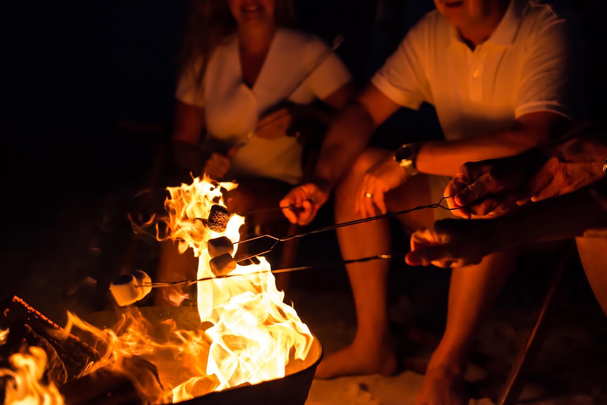 Roasting marshmallows over a bonfire on the Watersound Beach Club private beach