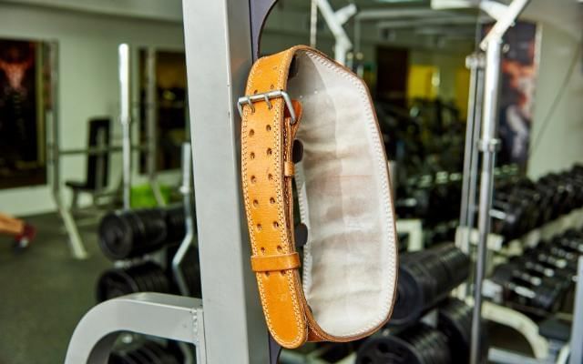 What do weightlifting belts do featuring a belt hanging in the gym