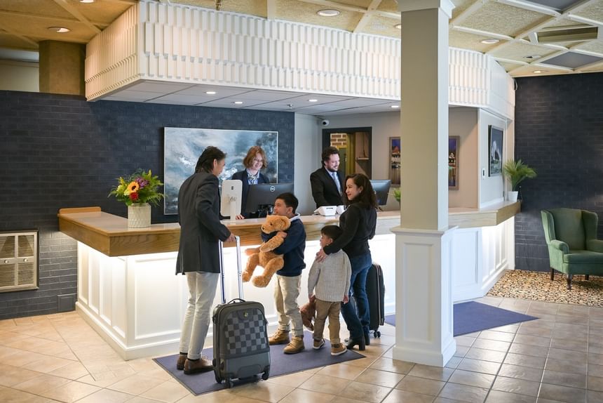 Family checking in at the front desk of Rodd Grand Yarmouth, receiving a warm welcome from the lobby staff