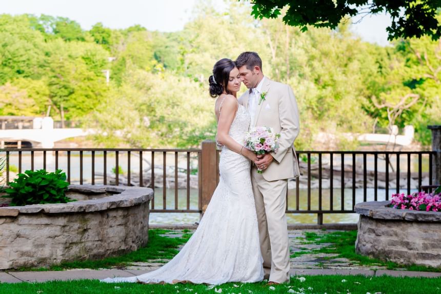 Bride & groom posing with river view, The Herrington Inn & Spa