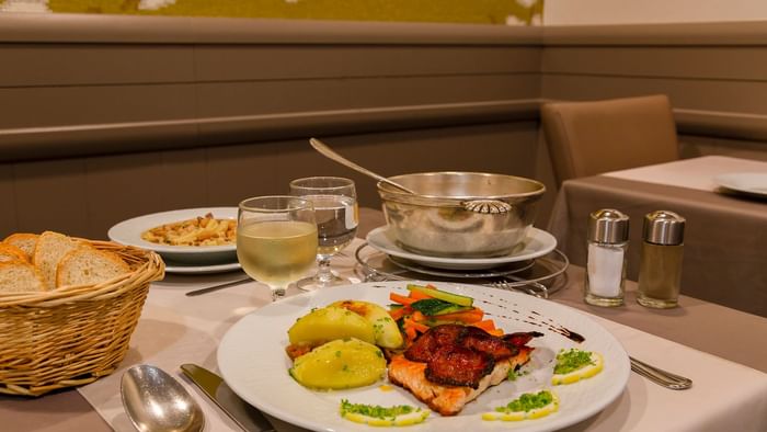 A chef preparing dishes at Hotel le Grillon D'or