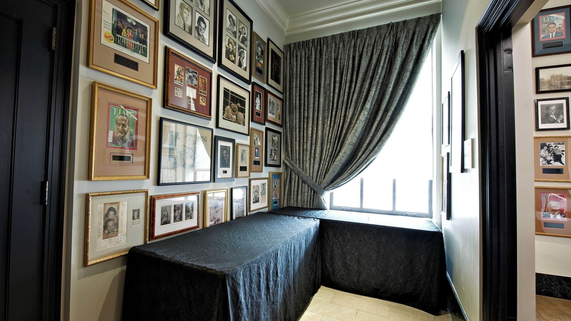 Long table covered with black cloth by a wall with framed pictures at Mayo Board Room, The Mayo Hotel, Tulsa.