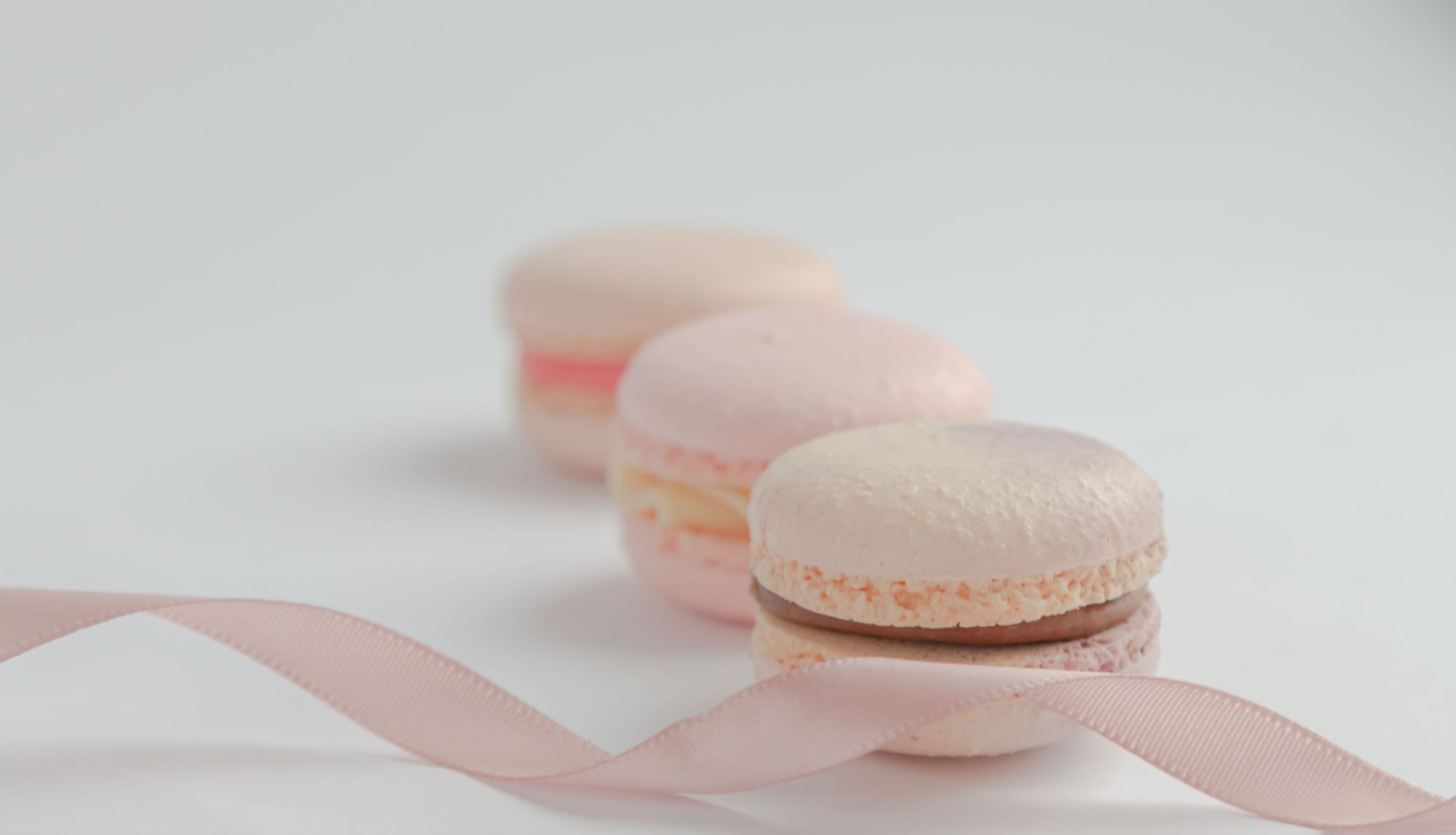 Three pink macarons with a delicate ribbon at Fullerton Sydney