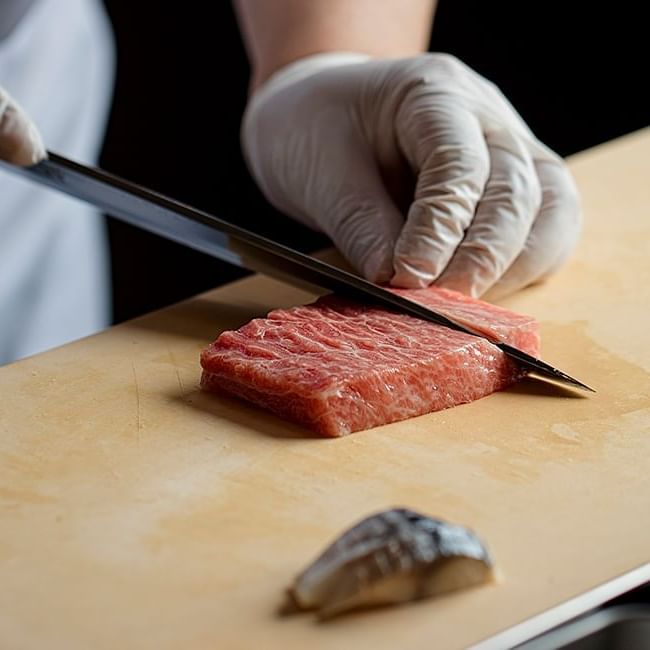 Chef cutting fresh raw meat in Yamazato at Hotel Okura Manila
