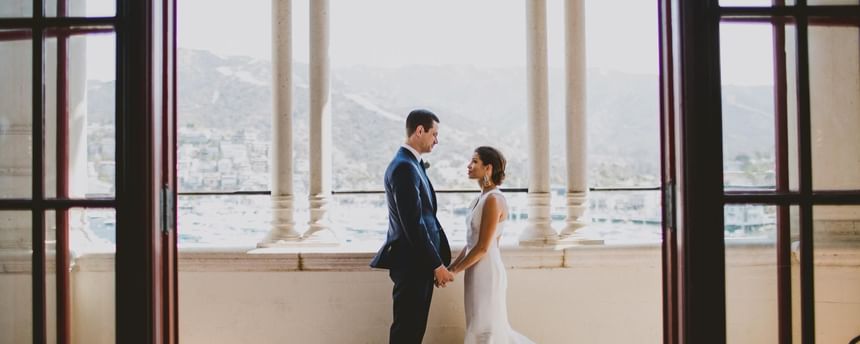 Wedded couple holding hands on the balcony at Catalina Island Company