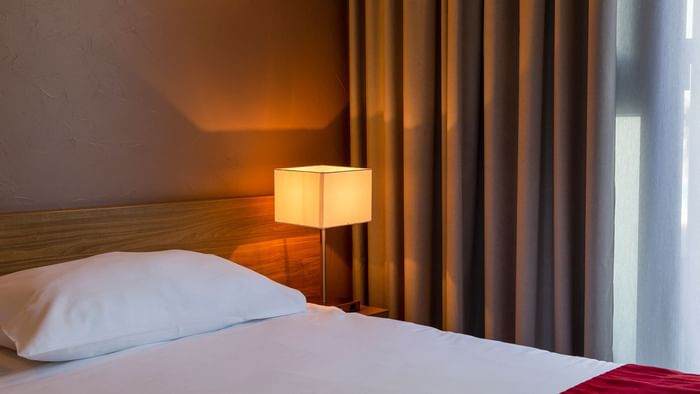 Closeup of a Bedroom at Hotel Le Sextant with a lamp