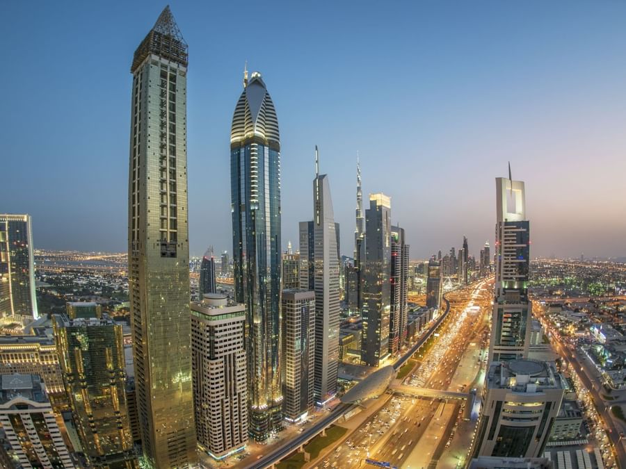 Twilight cityscape with skyscrapers and busy roads near DAMAC Hotels & Resorts, the best apartment hotels in Dubai