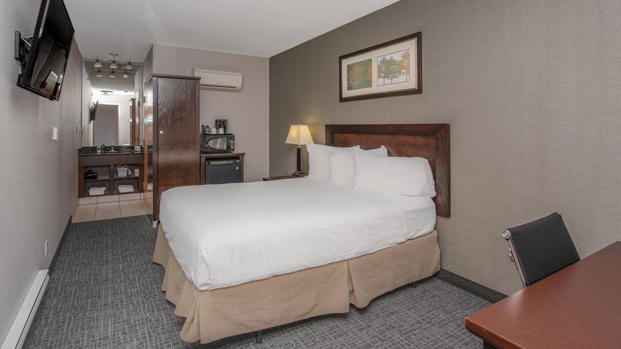 A queen room with a bed and desk.