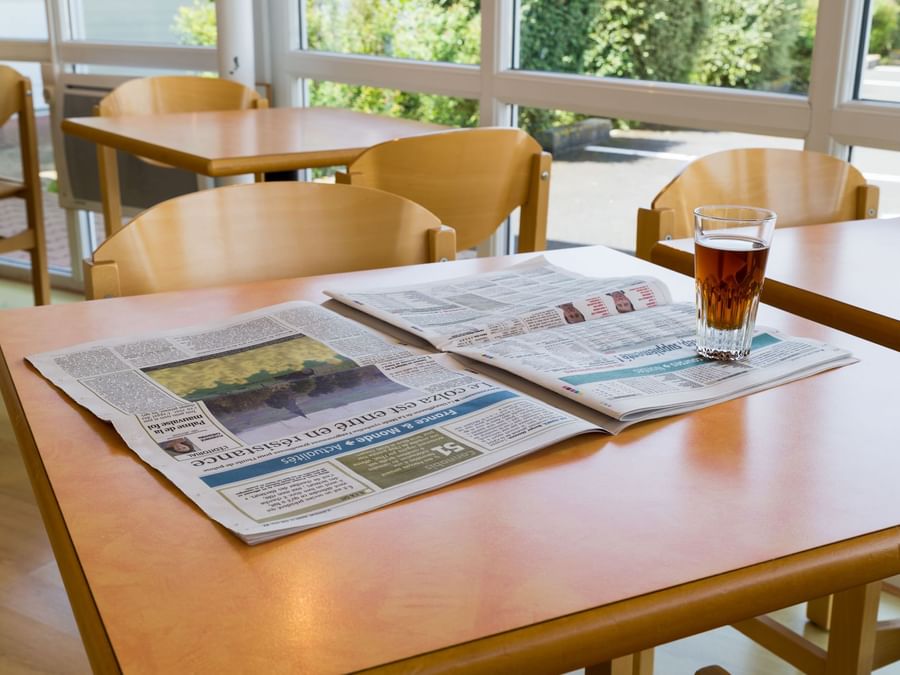 A newspaper & tea in a dining table in Hotel Saint-Flour
