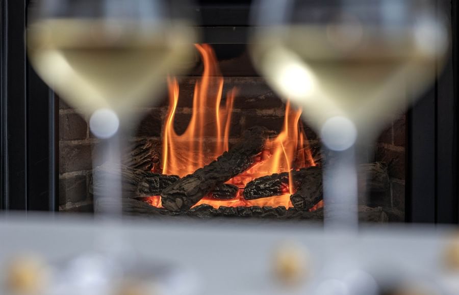 Close-up of two wine glasses in front of a fireplace at Warwick Le Crystal Montreal