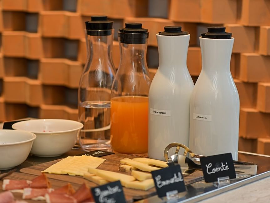 Plateau de fromages et de charcuteries avec des carafes de boissons au Hôtel Rivella.