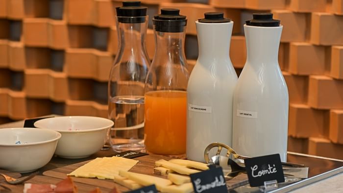 Plateau de fromages et de charcuteries avec des carafes de boissons au Hôtel Rivella.