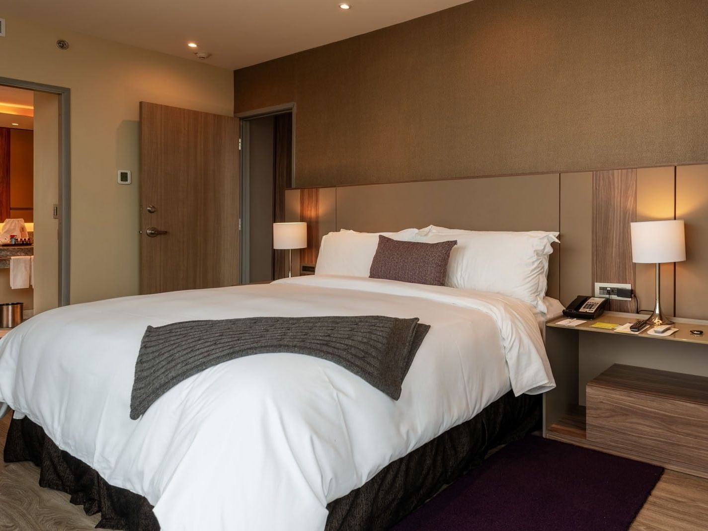 King Master Suite with a king bed, a grey throw blanket, & an open door  at Camino Real Fashion Drive, Monterrey