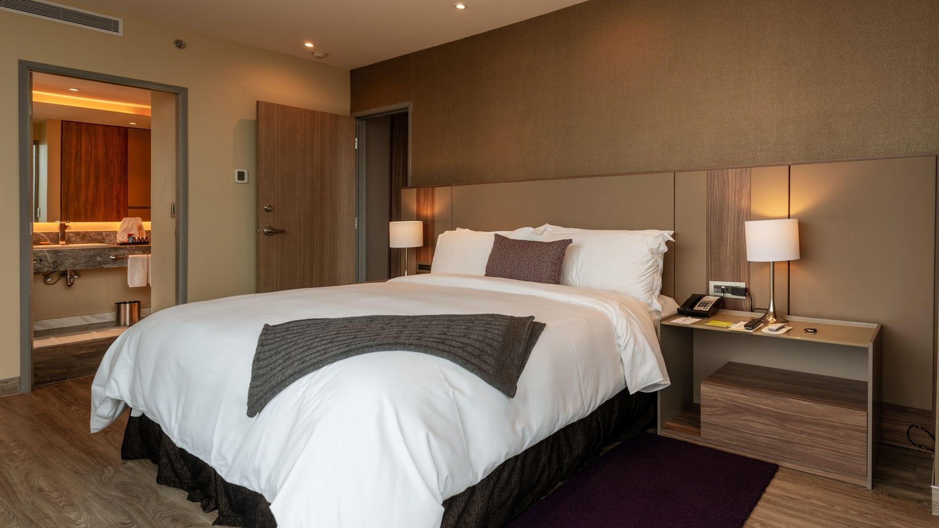 King Master Suite with a king bed, a grey throw blanket, & an open door  at Camino Real Fashion Drive, Monterrey