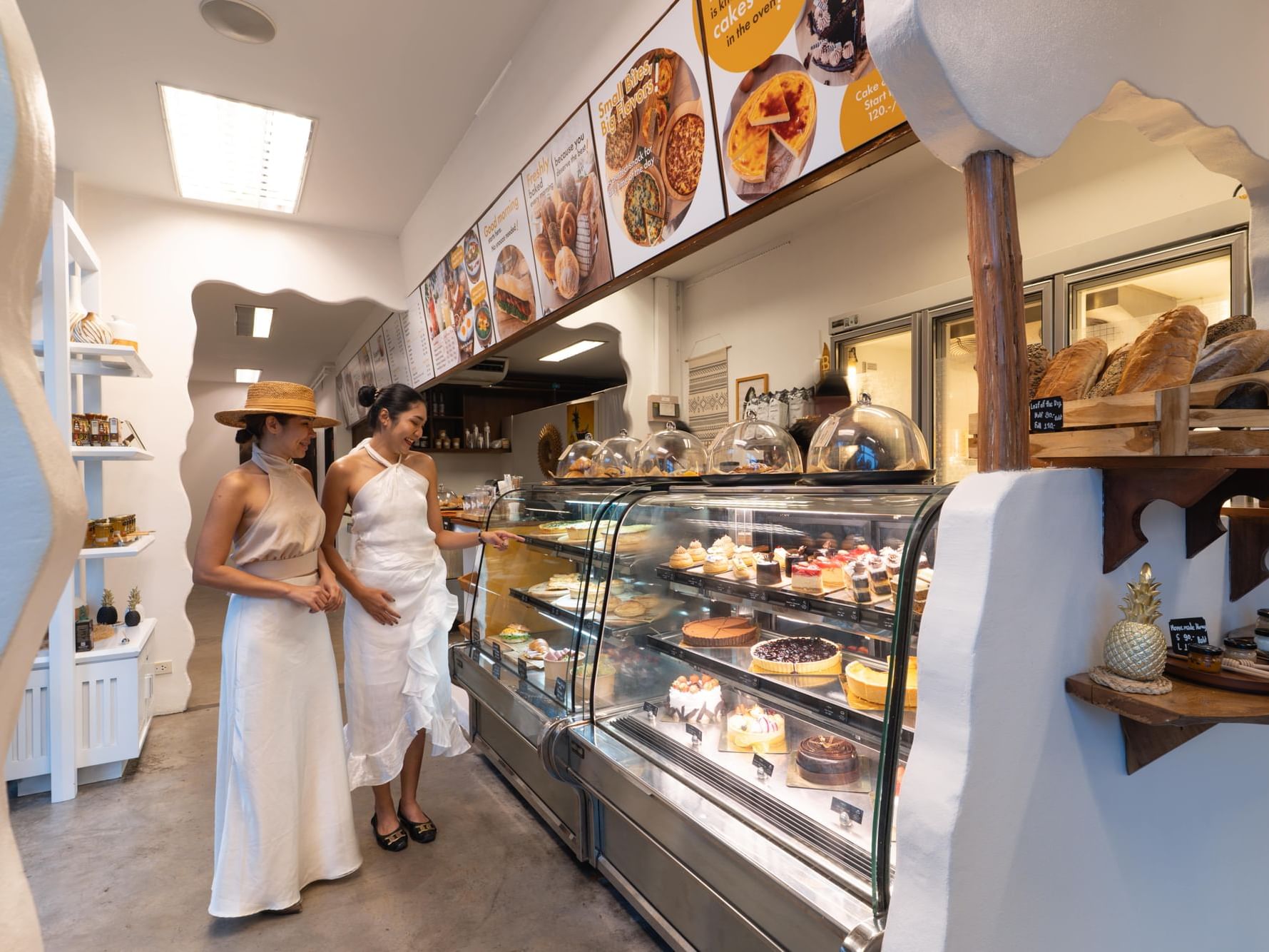2 women are standing and choosing the cakes and pastries at the Cafe Studio Karon Beach