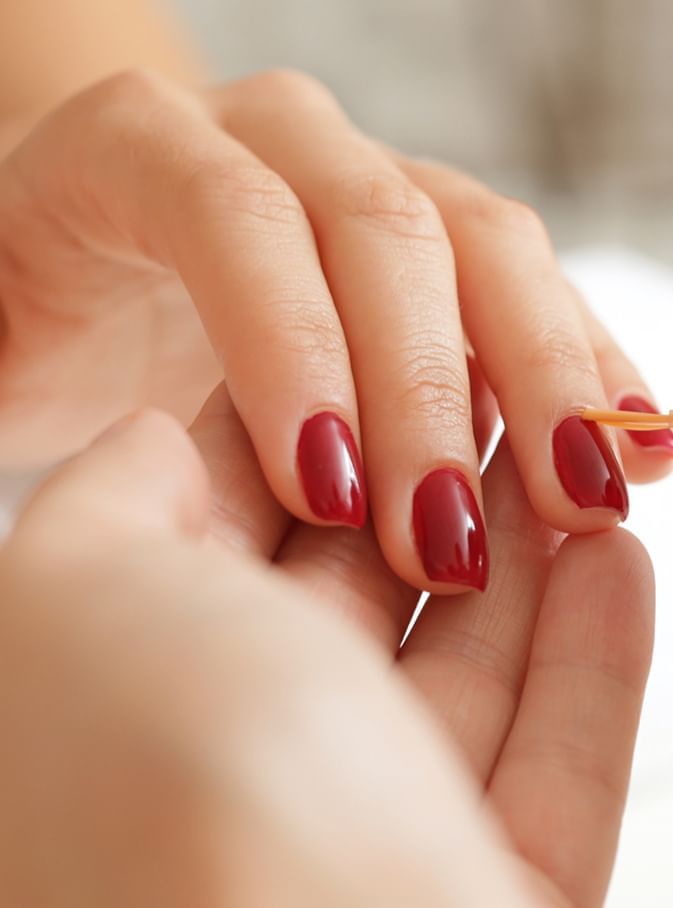 Close-up of a hand with elegant red nail polish at The Spa by Warwick Melrose