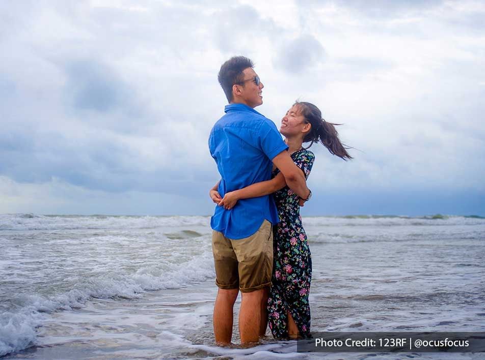 couple hugging to celebrate love on tropical ocean water - Grand Lexis PD