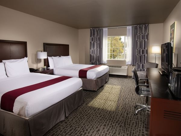 Two beds in stylish hotel room with window