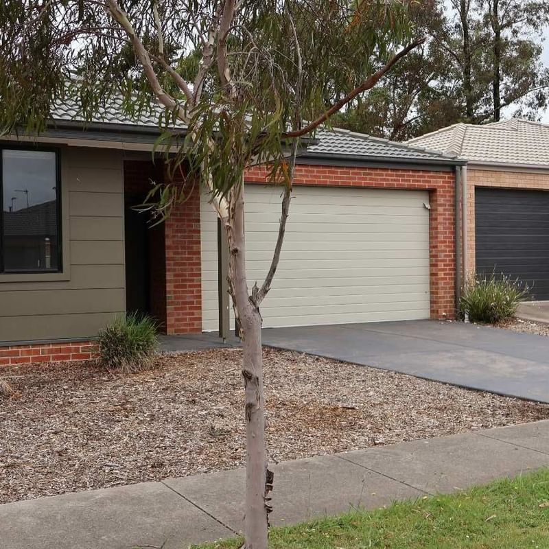 Modern house exterior with two garages and a tree at La Trobe University Regional Housing.