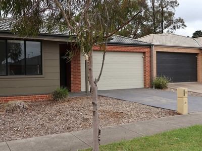 Modern house exterior with two garages and a tree at La Trobe University Regional Housing.