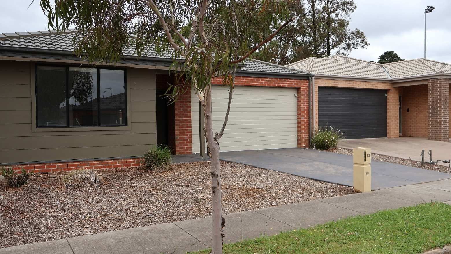 Modern house exterior with two garages and a tree at La Trobe University Regional Housing.