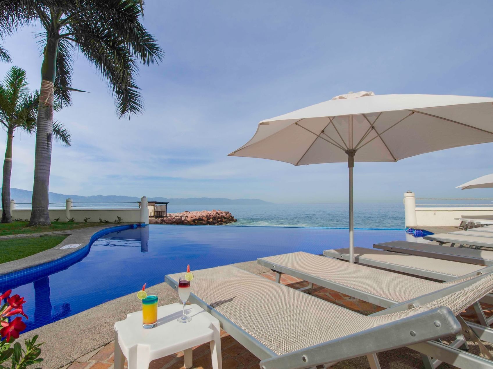 Poolside relaxation with lounge chairs at Plaza Pelicanos Grand Beach Resort