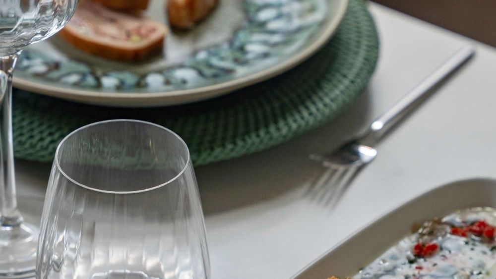 Gourmet appetizer served on a white plate by a green woven placemat in Le Céladon at Warwick Hotels and Resorts