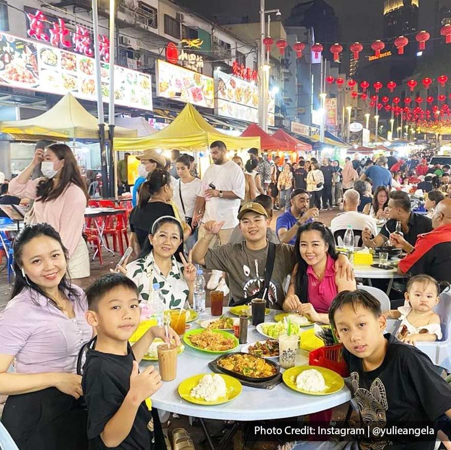 Big family enjoying street food from Jalan Alor at night near Imperial Lexis Kuala Lumpur