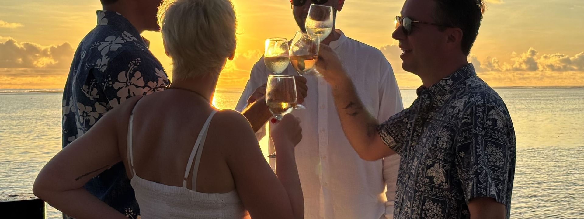 Guests toasting with wine at Wicked Walu, sunset view, at Warwick Fiji Resort and Spa, Korolevu