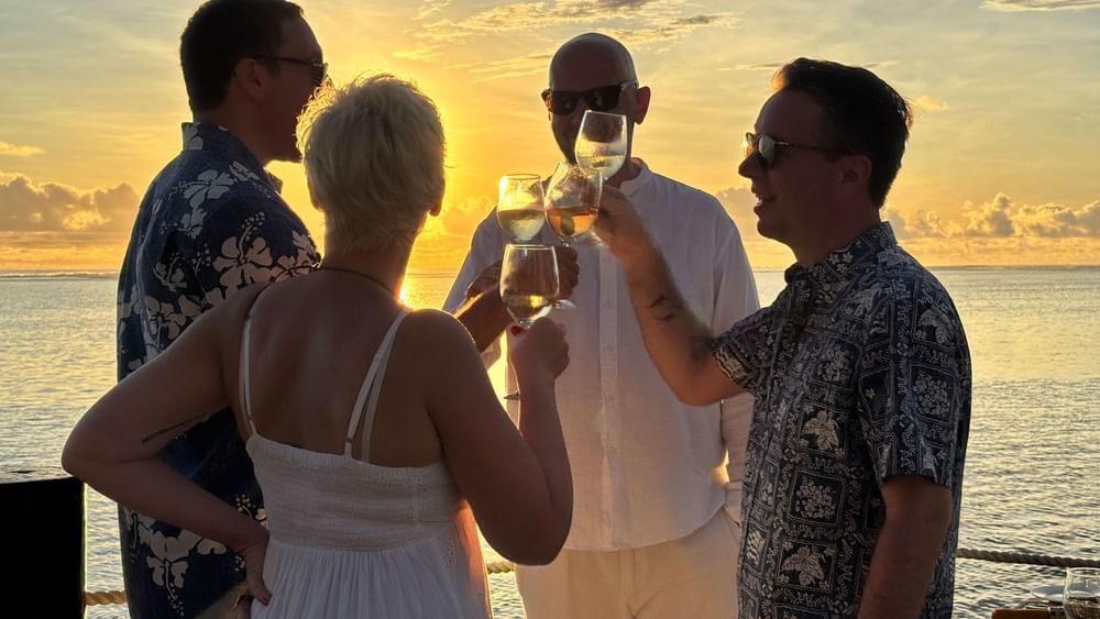 Guests toasting with wine at Wicked Walu, sunset view, at Warwick Fiji Resort and Spa, Korolevu.