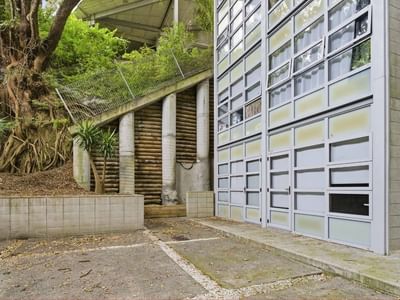 Modern building with glass windows and wooden structure at Student Living Auckland - Beach.