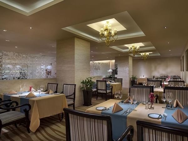 Dining tables arranged in Rainbow Room Western Restaurant at Celebrity International Grand Hotel