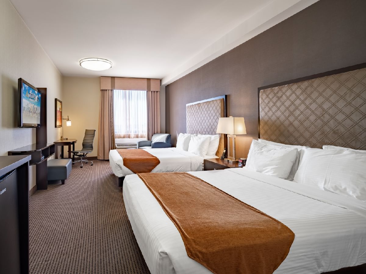 Two beds, TV & work desk in Platinum Two Queen Beds at Acclaim Hotel Calgary