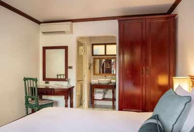 Bed with closet and bathroom vanity area in Superior Pondside View at U Luang Prabang